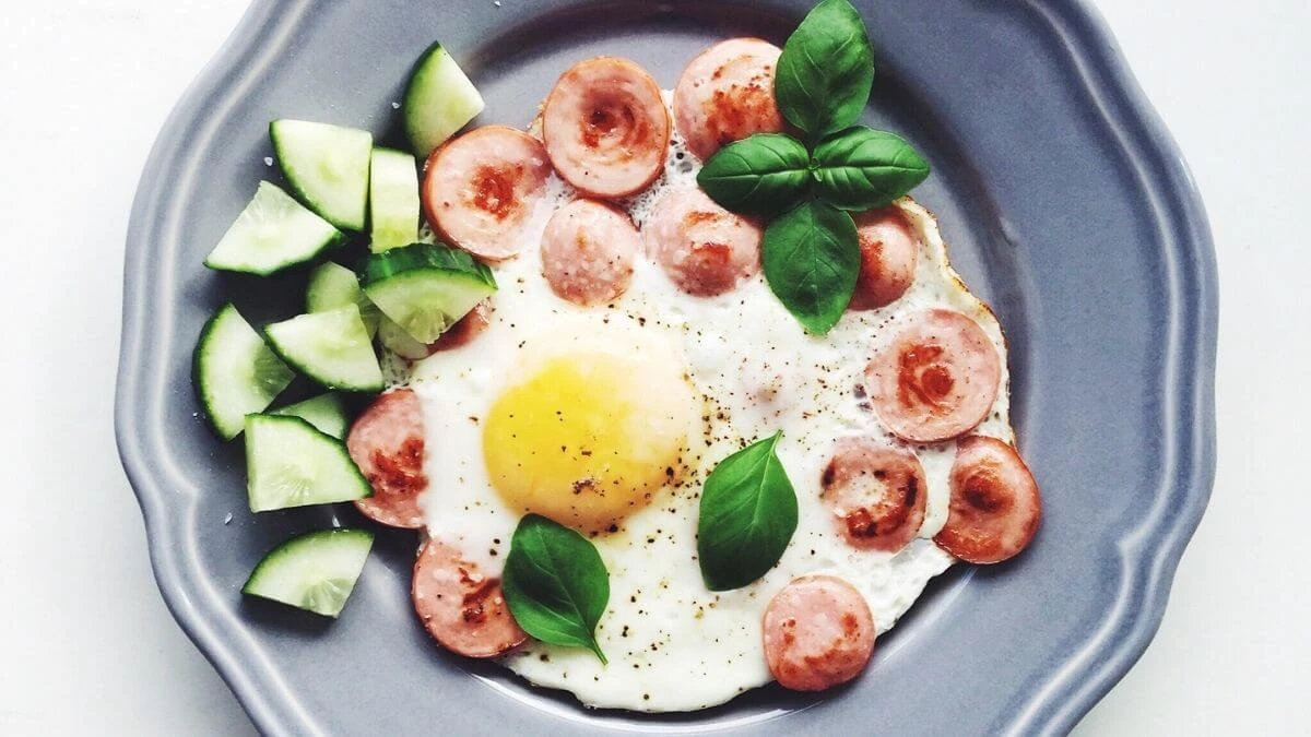 Fried egg with sliced sausage