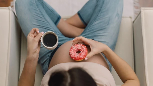 Pregnant woman eating donut