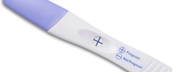 positive blue dye pregnancy test with plus sign (+)